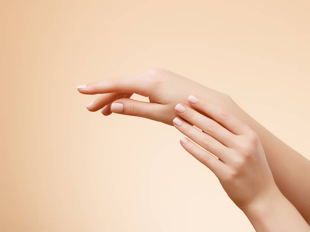 Detailní snímky z rukou krásná žena s světle růžová manikúra na nehty. Péče o ruce, manikúru a kosmetické ošetření. Elegantní a ladné ruce s štíhlé prsty - Fotografie, Obrázek