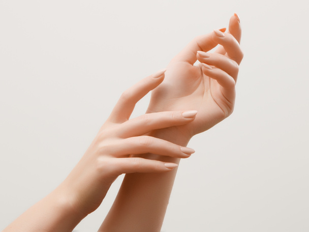 Immagine primo piano delle mani della bella donna con manicure rosa chiaro sulle unghie. Cura della pelle per le mani, manicure e trattamenti di bellezza. Mani eleganti e aggraziate con dita sottili e aggraziate
 - Foto, immagini