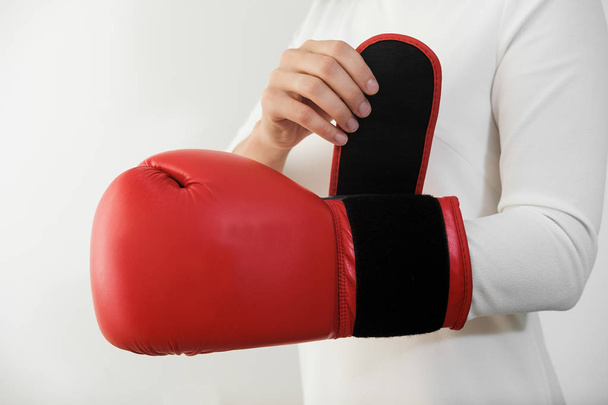 woman on white dress putting on red boxing gloves. Feminism, girl power, fight, gender, woman rights concept  - Photo, Image