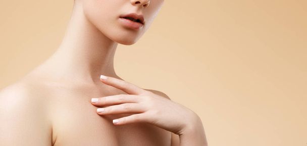 Beauty Spa Woman with perfect skin Portrait. Beautiful blond Spa Girl. Proposing a product. Gestures for advertisement. Beige background - 写真・画像