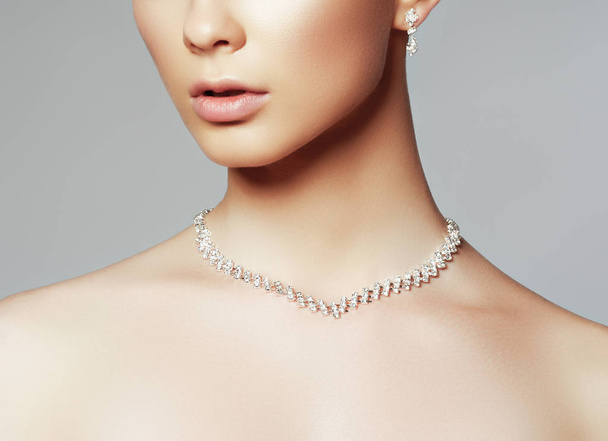 Красивая женщина в ожерелье, серьги. Модель из драгоценных камней, бриллиантов. Красивая часть женского лица. Перфект чистой кожи
 - Фото, изображение