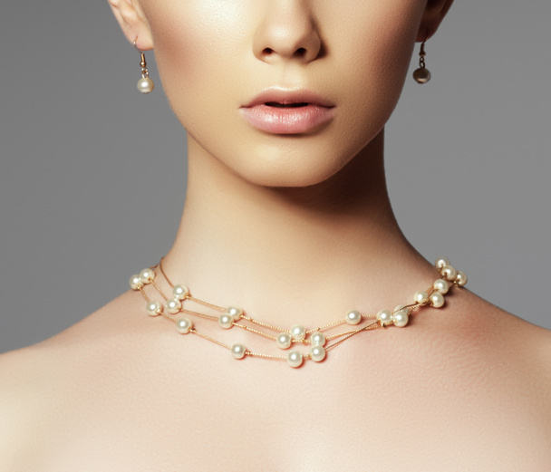 Beautiful woman in a necklace, earrings. Model in jewelry from precious stones, diamonds. Beautiful part of female face. Perfect clean skin - Fotoğraf, Görsel