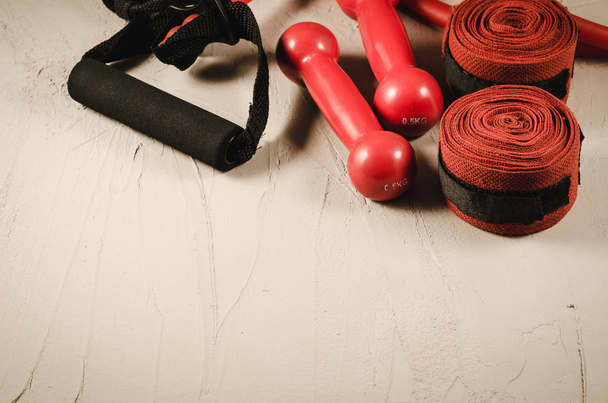 red dumbbells, bandage and jump rope/healthy concept with red dumbbells, bandage and jump rope on a dark background. Top view and copyspace - Fotó, kép