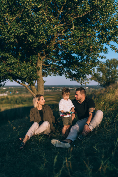 famille heureuse avec un enfant reposant ensemble sur l'herbe verte
 - Photo, image