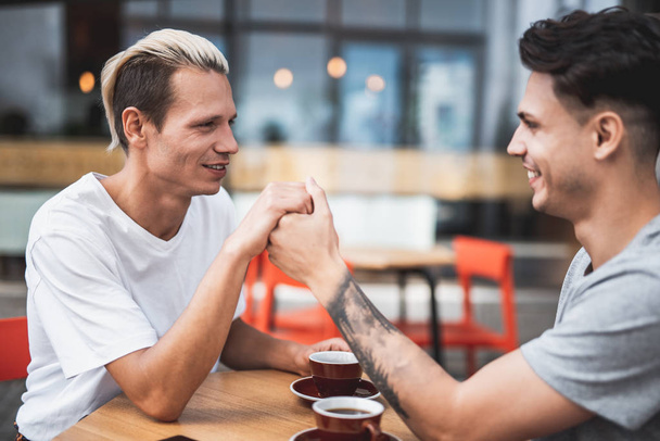 Ευχαριστημένος άνδρες δοκιμάζοντας νόστιμα καφέ στο καφέ - Φωτογραφία, εικόνα
