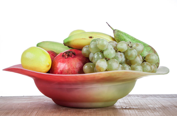 Granaatappels en andere vruchten in een kom - Foto, afbeelding