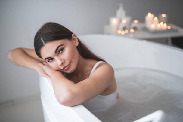 Thoughtful lady leaning on bath during procedure - Photo, Image
