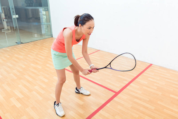 Jonge squash speler bezit is van het racket tijdens spel op een professionele rechter - Foto, afbeelding