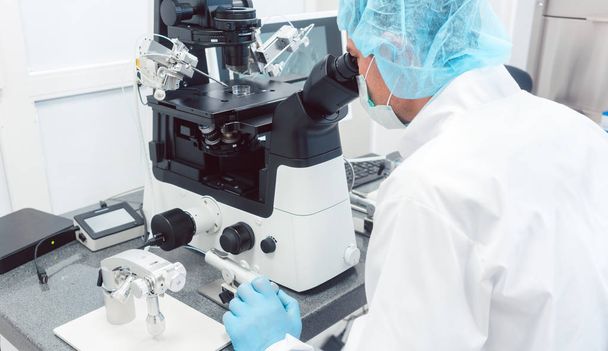 Доктор або вчений, дивлячись на власний мікроскоп в лабораторії
 - Фото, зображення