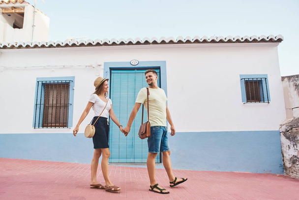 Happy and attractive young couple of travellers walking in old Spanish town on vacations. - Zdjęcie, obraz