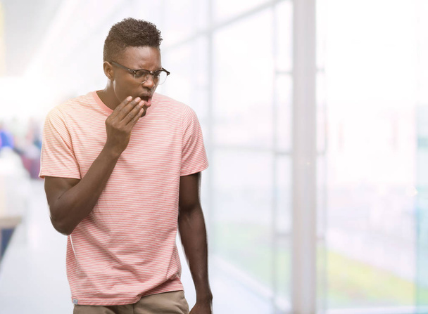 歯痛や歯の歯科病気のため痛みを伴う式で手で口の若いアフリカ系アメリカ人着てピンク t シャツに触れます。歯医者コンセプト. - 写真・画像