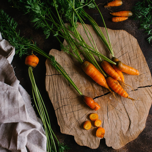Zanahorias y verduras sobre un fondo oscuro
 - Foto, Imagen