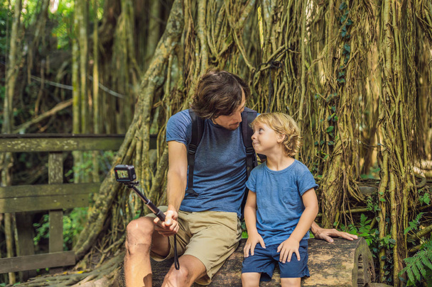 Dad and son taking selfie and discovering Ubud forest in Monkey forest, Bali, Indonesia.  - Foto, imagen