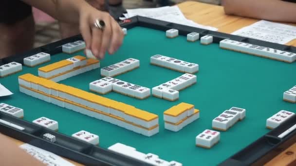 Ihmiset pelaavat Mahjong Aasian laatta-pohjainen peli. Taulukko Uhkapeli
 - Materiaali, video