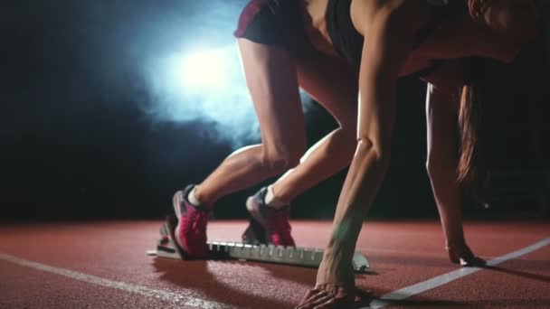 Kadın atlet karanlık bir arka plan üzerinde koyu arka plan üzerinde treadmill yastıkları arazi sprint çalıştırılmaya hazırlanıyor - Video, Çekim