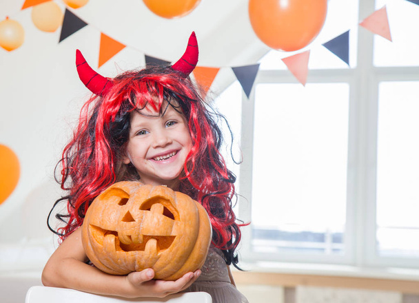 little girl in costumes with pumpkins for Halloween celebration - Foto, Bild