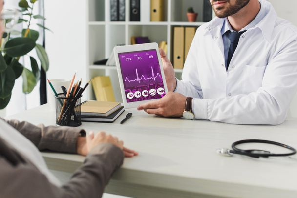 levágott kép mutatja a tablet app orvosi klinika beteg orvos - Fotó, kép