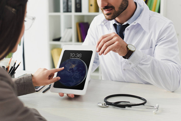 cropped image of doctor showing patient ipad in clinic - Foto, imagen