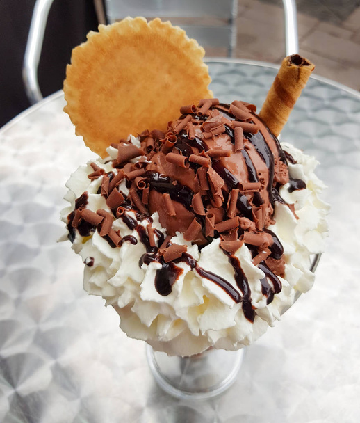 Κοντινό πλάνο του μια σοκολάτα παγωτό παγωτό σε ένα ασημένιο μεταλλικό τραπέζι. Υψηλή οπτική γωνία και ρηχό βάθος πεδίου. - Φωτογραφία, εικόνα