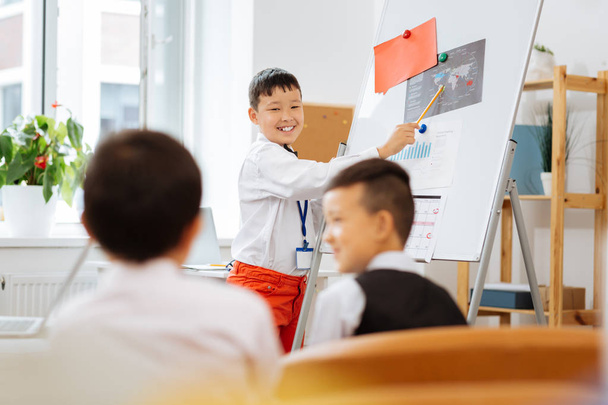 Happy boy standing next to the white board - 写真・画像