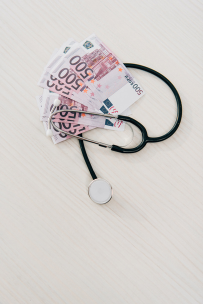 elevated view of stethoscope and euro banknotes on table in clinic, health insurance concept - Photo, Image