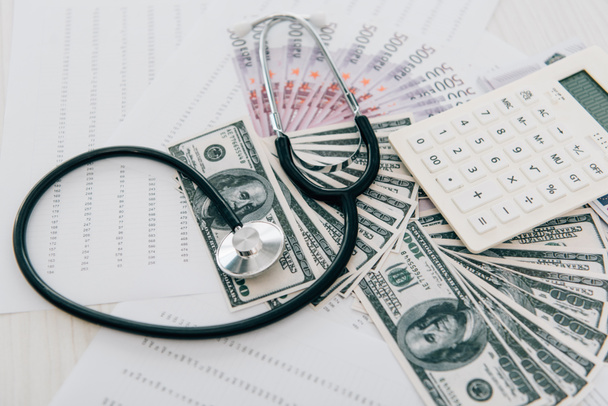 stetoscopio, denaro e calcolatrice sul tavolo in clinica, concetto di assicurazione sanitaria
 - Foto, immagini