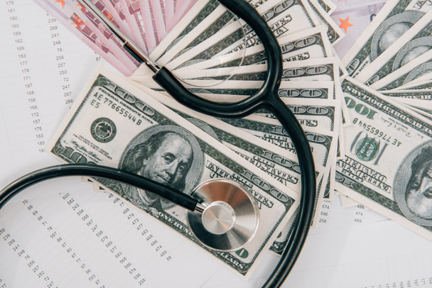 вид зверху на стетоскоп, доларові та євро банкноти на столі в клініці, концепція медичного страхування
 - Фото, зображення