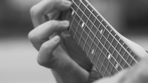 Spelen elektrische gitaar, 4k HD 23,976 filmische Stock Footage, close-up op de vingers van de mens het spelen van de gitaar - Video