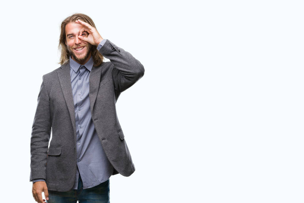 Young handsome business man with long hair over isolated background doing ok gesture with hand smiling, eye looking through fingers with happy face. - 写真・画像