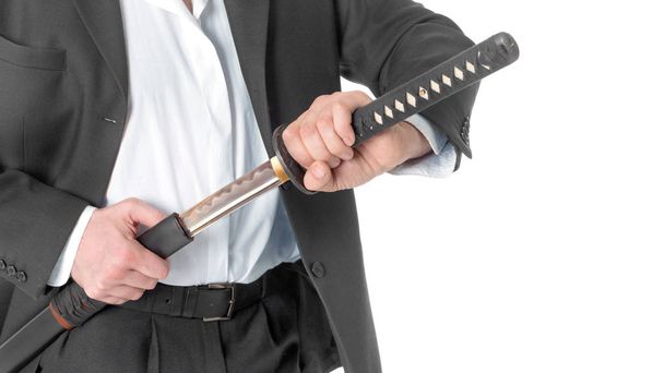 Close-up Of Businessman Removing Sword Over White Background. - Zdjęcie, obraz