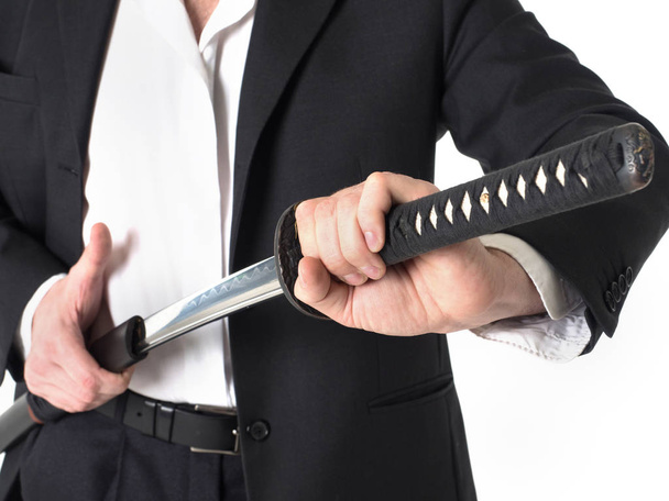 Közeli kép: üzletember eltávolítása a kard alatt fehér háttér. - Fotó, kép
