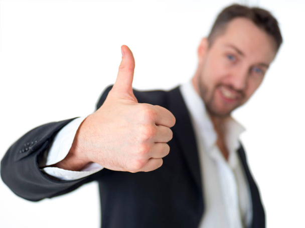 Smiling businessman with thumb up, isolated on white background. Focus on the hand. Blurred man - Foto, afbeelding