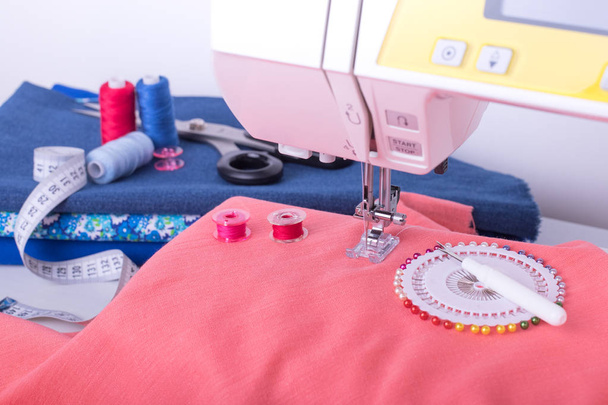 Different Accessories Of Sewing, Sewing Machine And Fabrics Close Up. Work In Needlework Workshop. - 写真・画像