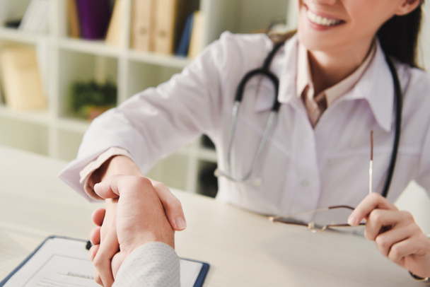 cropped view of client and doctor shaking hands in office - Foto, Imagem