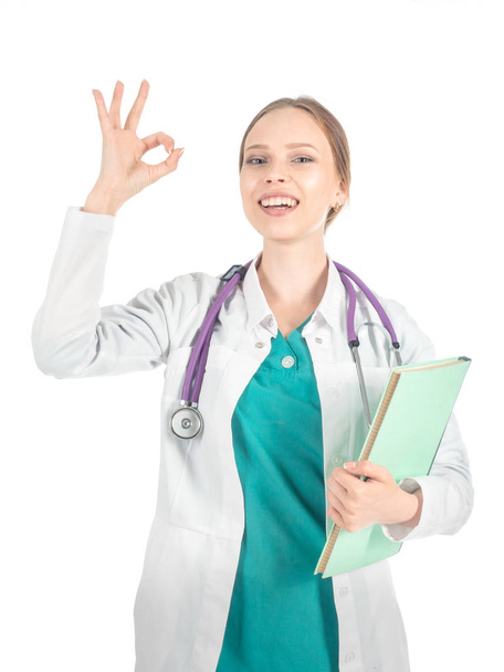 Young beautiful female doctor with stethoscope showing allright sign. - Foto, imagen