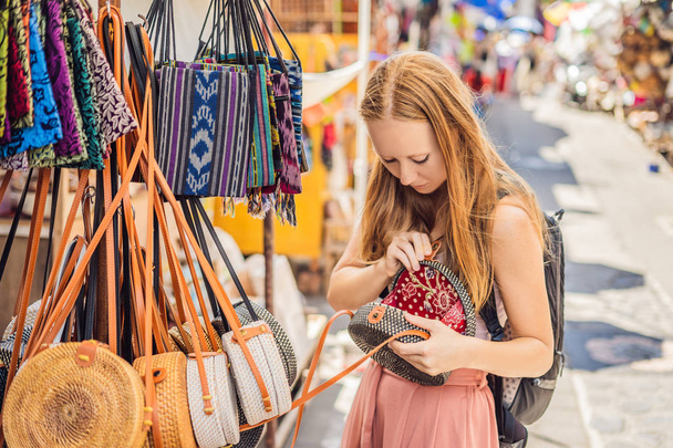 Fiatal nő választja a híres balinéz rattan öko táskák egy helyi szuvenír piac, Bali, Indonézia - Fotó, kép