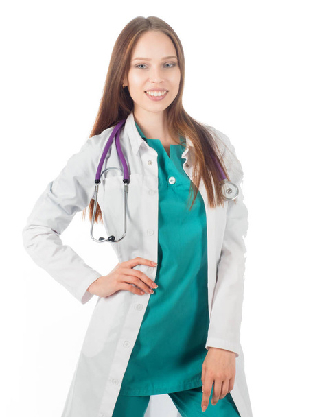 Lächelnde Ärztin mit Stethoskop steht isoliert auf weißem Hintergrund. - Foto, Bild