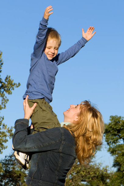 happy mother and son having fun in park - Фото, зображення