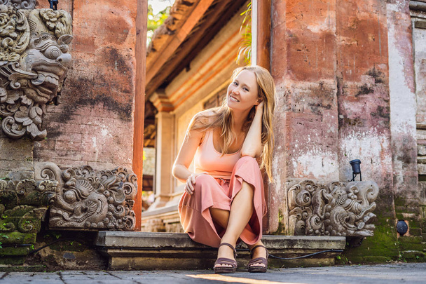 Young woman traveler sitting by Ubud palace, Bali, Bali, Indonesia. - Foto, Imagen