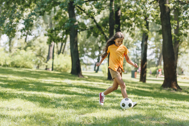 beautiful happy child playing with soccer ball in park  - Photo, Image