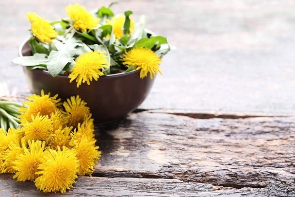 Yellow dandelions on wooden table - Фото, изображение