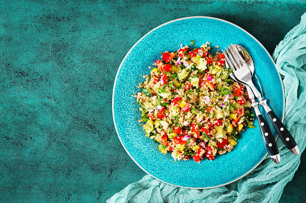 Salata quinoa, roka, tatlı biber, domates ve salatalık kase karanlık bir arka plan üzerinde. Sağlıklı gıda, diyet, detoks ve vejetaryen kavramı. Tabbouleh salata. Üstten görünüm. Düz yatıyordu - Fotoğraf, Görsel