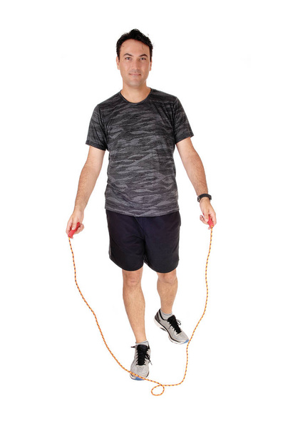 A young man standing in the studio exercising with his rope, in a sport - Photo, Image