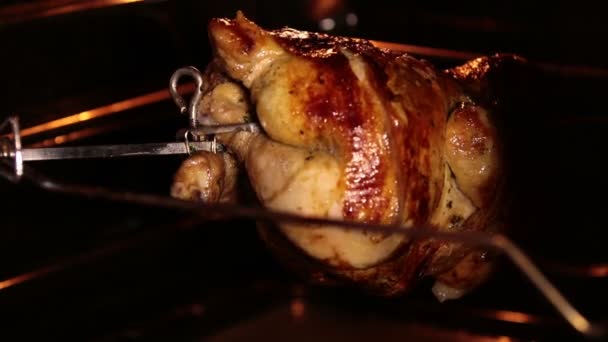 Готовить жареного цыпленка на гриле слюной в духовке. Коричневая курица вращается во время жарки под гриль-элементом. Внутренний вид
. - Кадры, видео