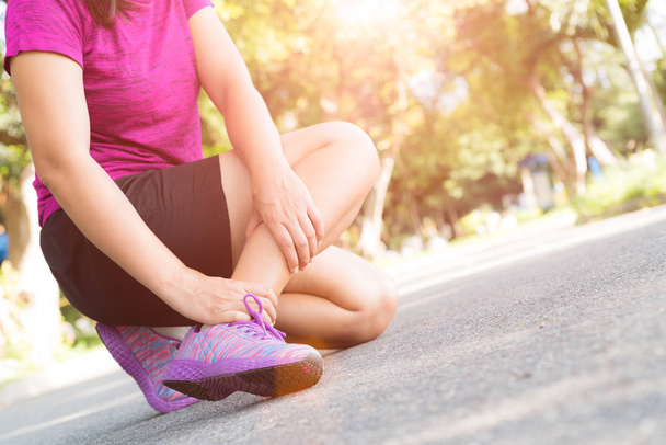 Mujer que sufre de una lesión en el tobillo mientras hace ejercicio. Correr concepto de lesión deportiva
. - Foto, imagen