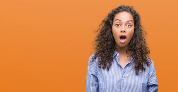 Young hispanic business woman afraid and shocked with surprise expression, fear and excited face. - Photo, Image