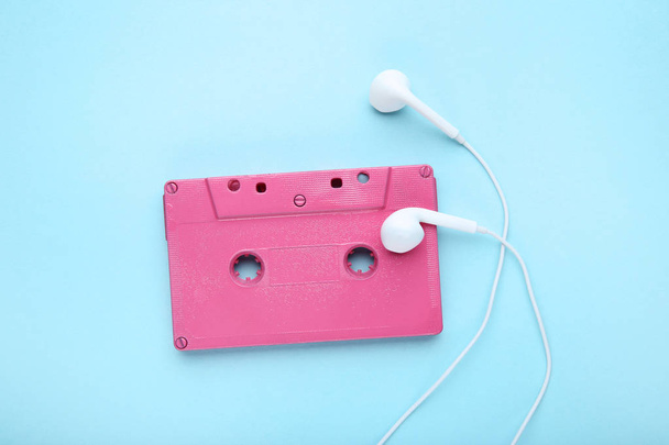 Cassette tape with earphones on blue background - Фото, зображення