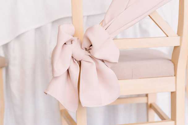 Bow of gentle pink color on a chair back. - Fotó, kép