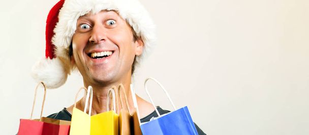 Ευτυχισμένος άνθρωπος Santa Χριστούγεννα με τσάντες αγορών, απομονώνονται σε λευκό φόντο. Διακοπές, Χριστούγεννα, πώληση και άνθρωποι έννοια. Αστείος άνθρωπος Ψώνια για χριστουγεννιάτικα δώρα. Χώρο αντίγραφο - Φωτογραφία, εικόνα
