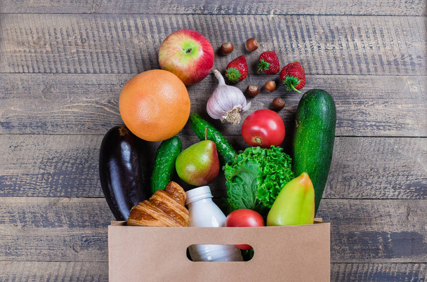 Healhty τροφίμων. Ψώνια χαρτί τσάντα με φρούτα και λαχανικά σε φόντο ξύλινο τραπέζι. Το Top view. Επίπεδη θέσει. Χώρο αντίγραφο - Φωτογραφία, εικόνα